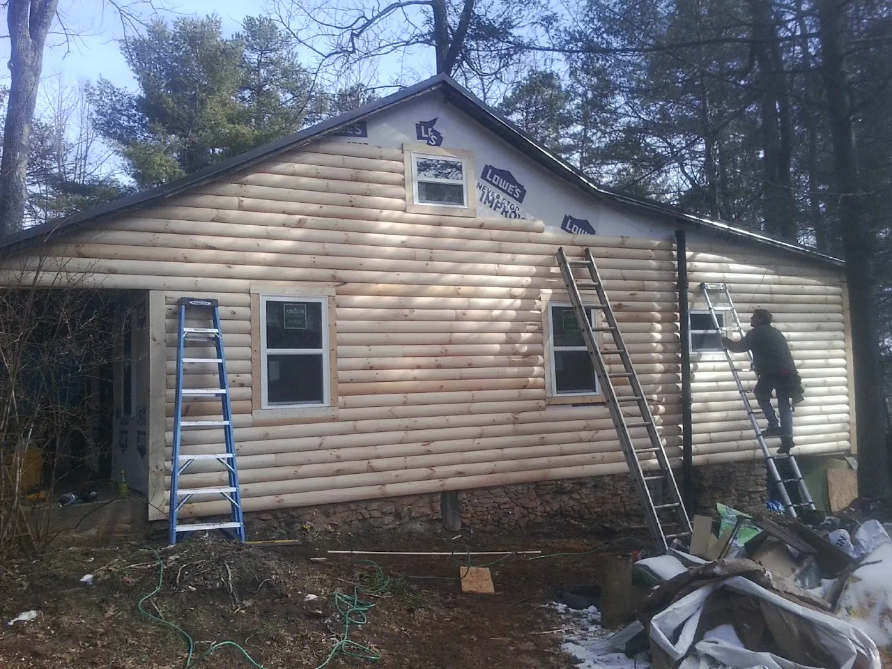 Ladders set against fresh log siding during an exterior remodel in Farmville